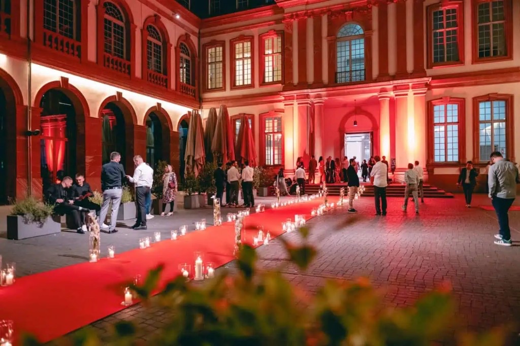 Evening gala in Frankfurt with red carpet, candle lighting and illuminated palace courtyard